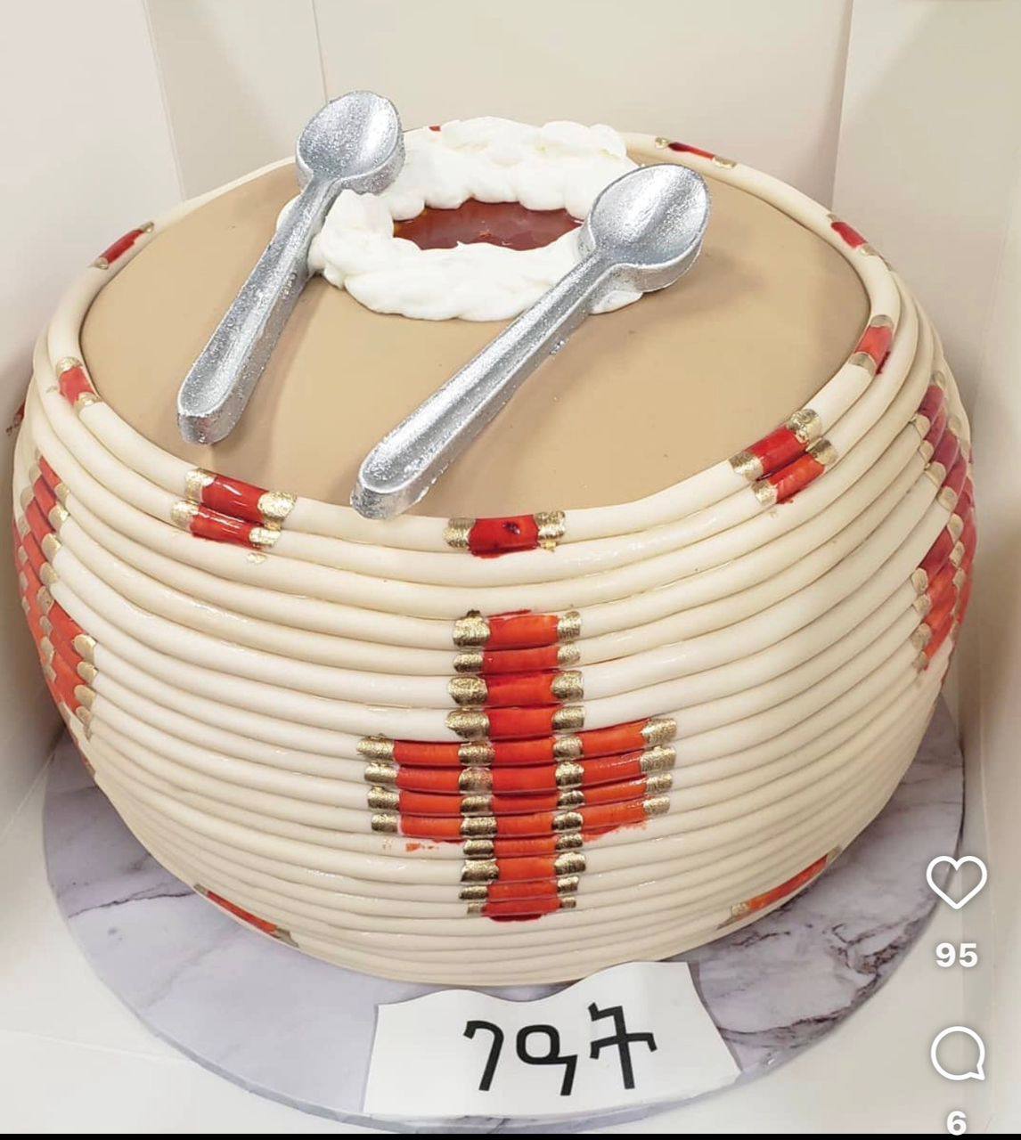 Woven fondant coffee-ceremony cake with a red and gold cross pattern and silver spoon toppers
