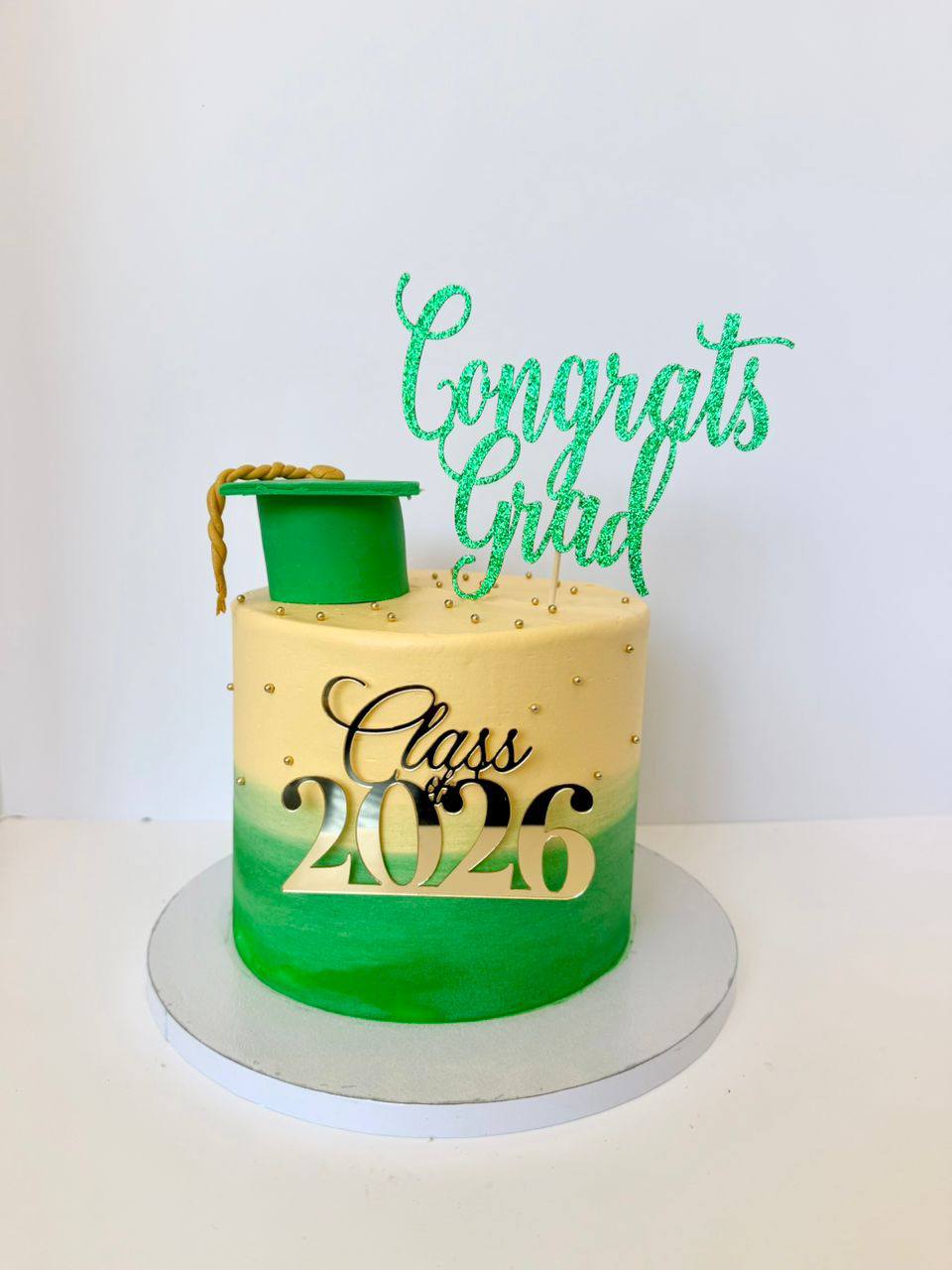 Ivory to green ombre graduation cake with a green fondant cap and glitter 'Congrats Grad' topper, Class 2026